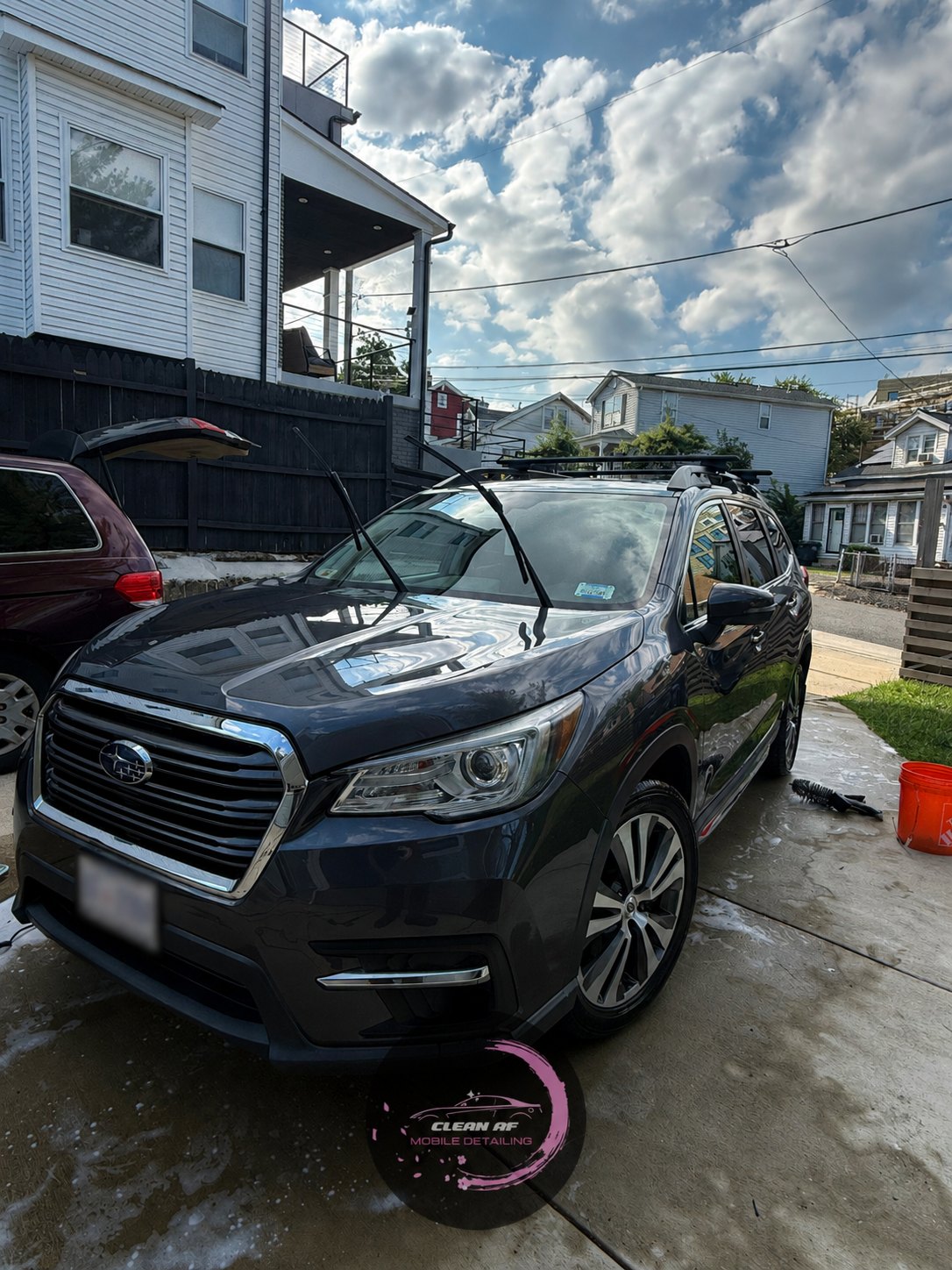 Clean AF team member beside a freshly detailed vehicle
